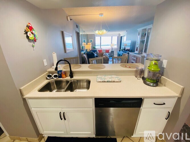 A kitchen with a sink, dishwasher, and a countertop.