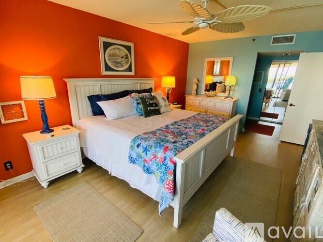 A bedroom with a large bed and a ceiling fan.