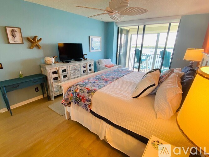 A bedroom with a bed, a television, and a window with a view.
