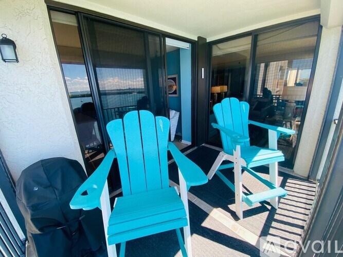 Two blue chairs are on a patio.