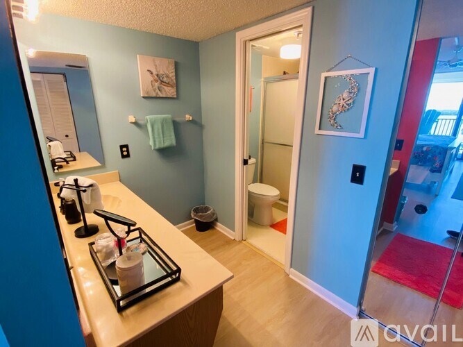 A bathroom with a toilet, sink, and mirror.