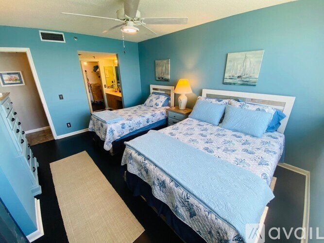 A bedroom with two beds and a ceiling fan.