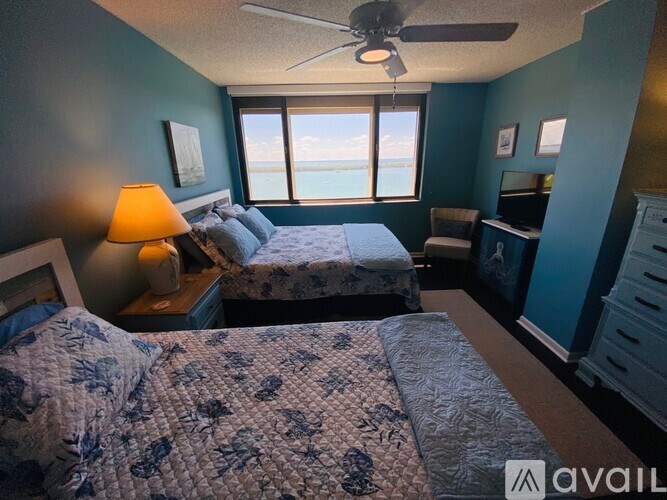 A bedroom with two beds and a ceiling fan.