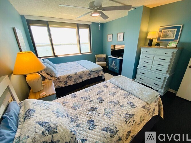 A bedroom with two beds and a ceiling fan.
