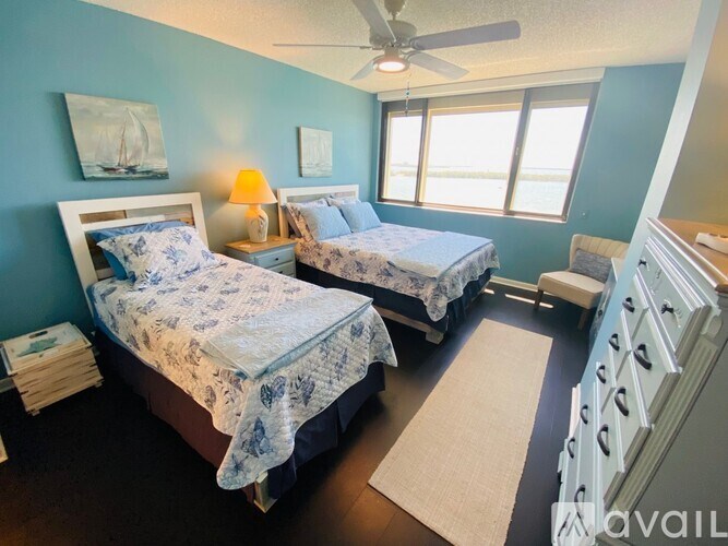 Two twin beds with blue bedspreads in a room with blue walls.