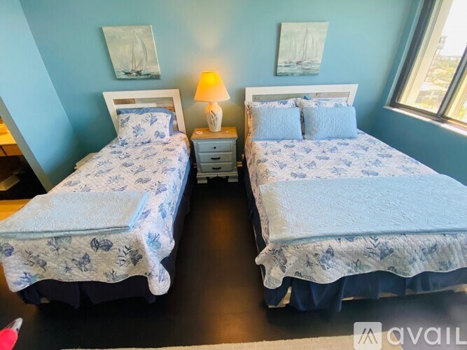 Two twin beds with blue and white bedspreads in a room.