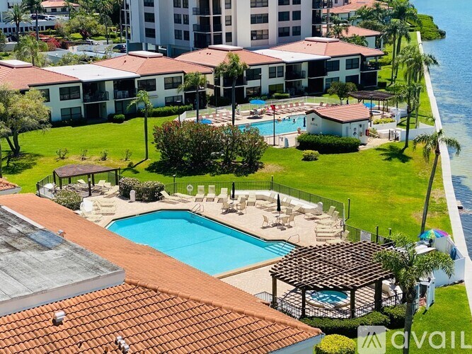 A large swimming pool surrounded by a grassy area and a building in the background.