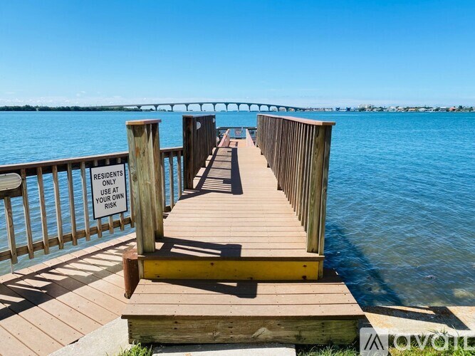 A wooden pier with a sign that says "Residents Only" and a yellow railing.