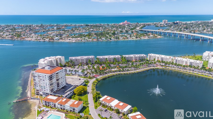 A bird's eye view of a coastal city with a large body of water and a bridge in the distance.