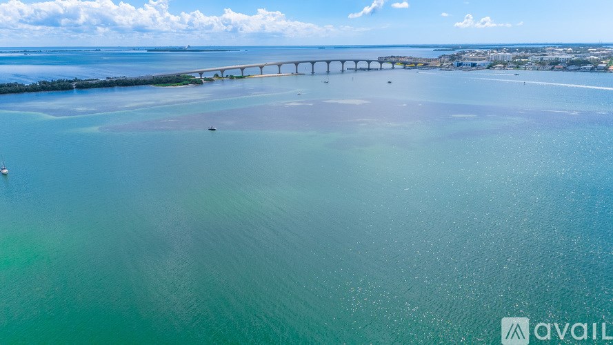 A bridge spans a calm body of water with a clear sky above.