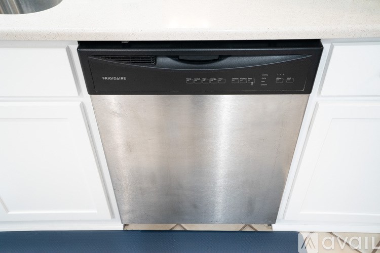 A dishwasher is built into a kitchen cabinet.