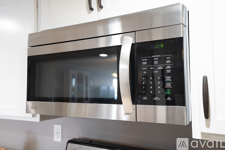 A stainless steel microwave oven with digital display and control panel.
