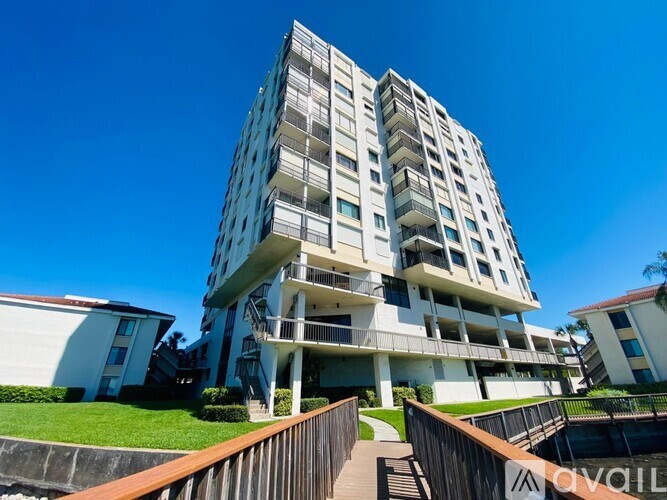 A modern multi-story residential building with balconies and a wooden deck in front.
