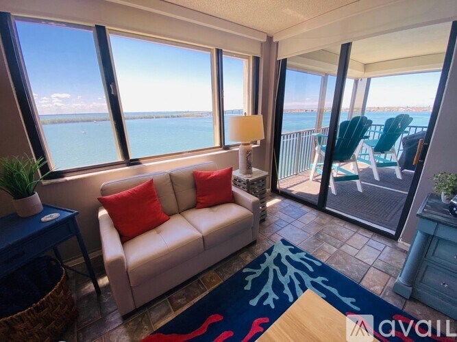 A living room with a couch, a table, and a view of the water.