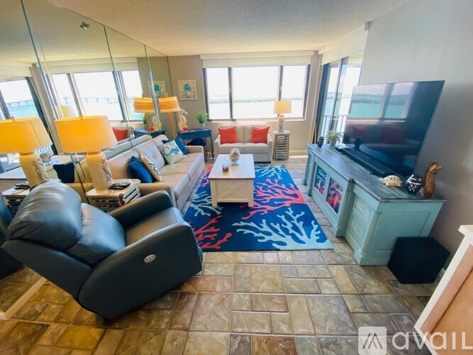 A living room with a blue couch and a black chair.