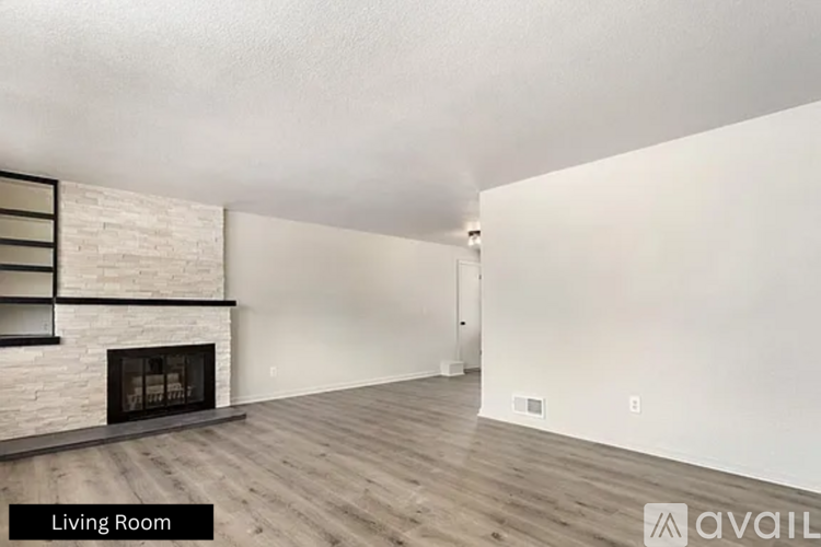 A living room with a fireplace and wooden floors.