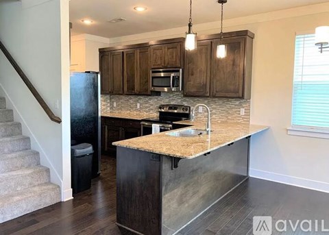 A kitchen with a granite countertop and wooden cabinets.