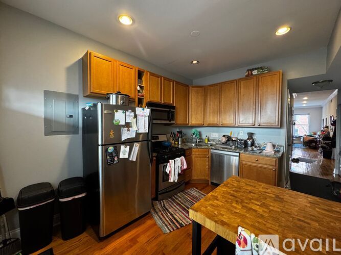 A kitchen with wooden cabinets and a stainless steel refrigerator.