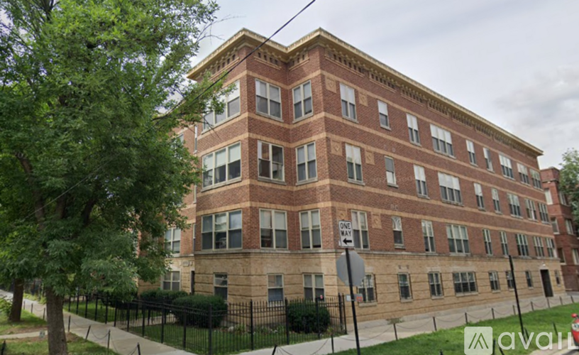 A large red brick building with a black fence in front.