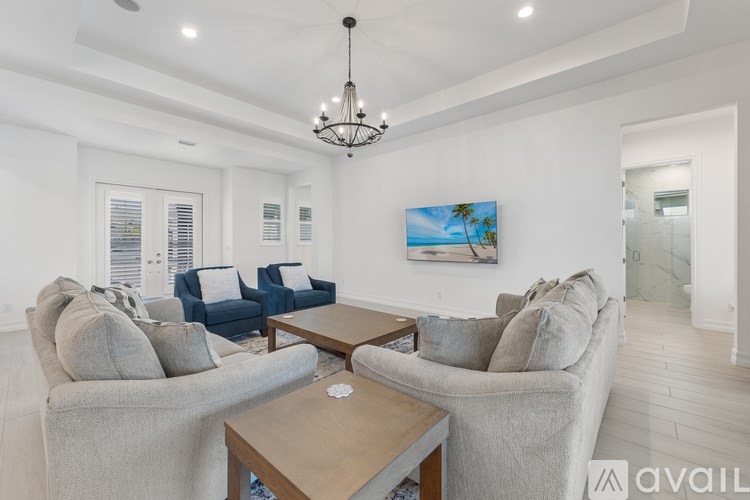 A living room with a grey couch, a wooden coffee table, and a painting on the wall.