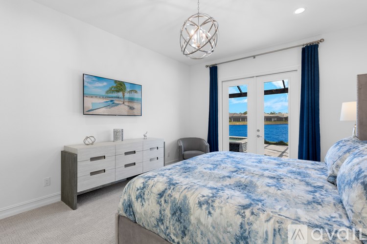 A bedroom with a large bed and a painting of a beach scene on the wall.