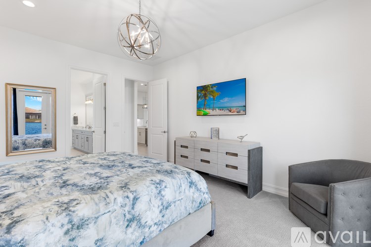 A bedroom with a bed, a chair, and a painting on the wall.