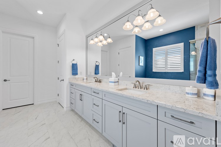 A bathroom with a white door and a marble countertop.