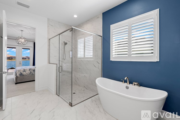 A modern bathroom with a white bathtub and a glass shower enclosure.