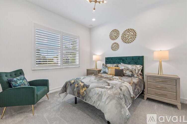 A bedroom with a bed, chair, and lamp.