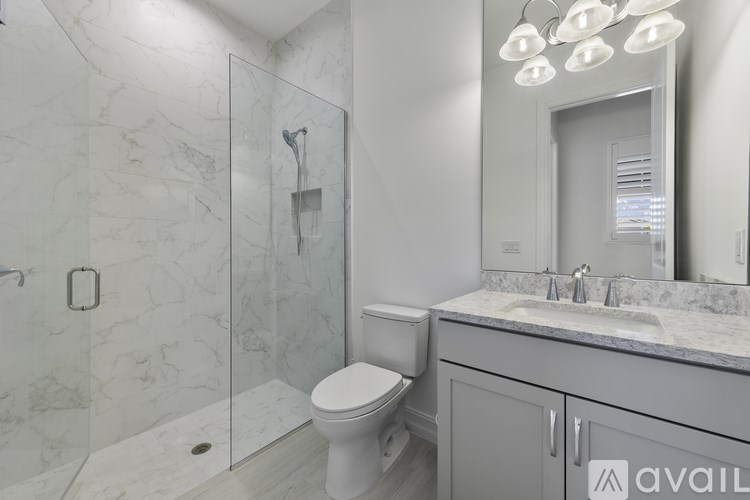 A bathroom with a marble wall and a walk-in shower.