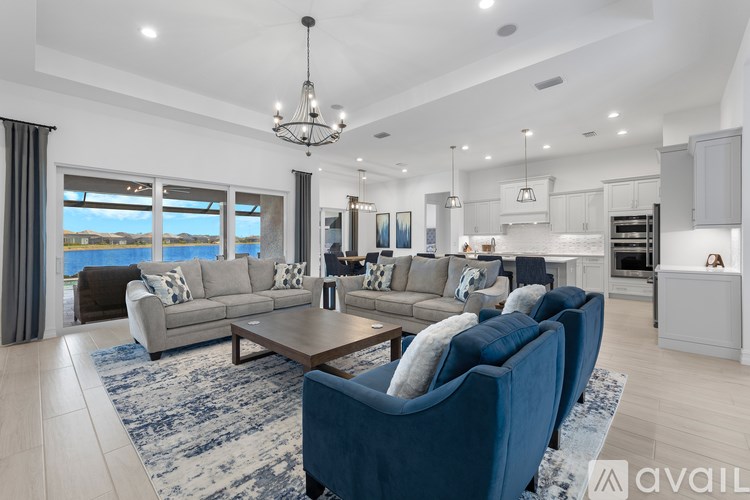 A modern living room with a large window overlooking the water.
