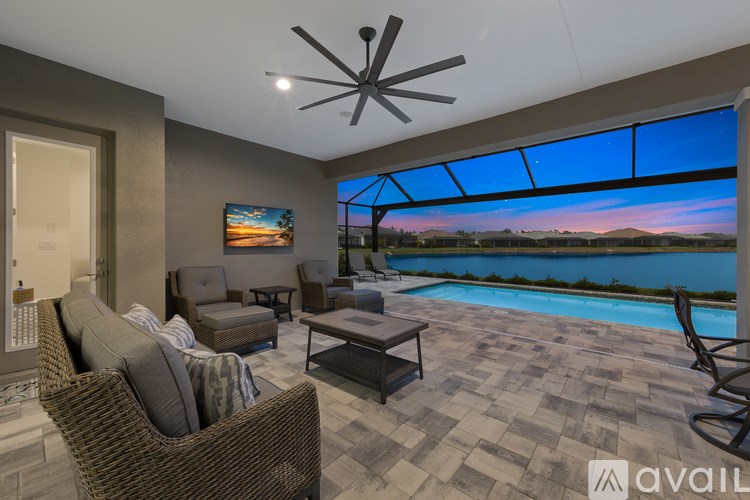 A living room with a large window overlooking a pool and a view of the mountains.