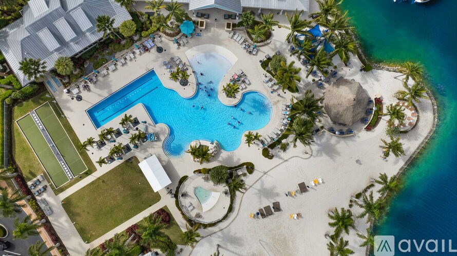 An aerial view of a resort with a large swimming pool and beach area.