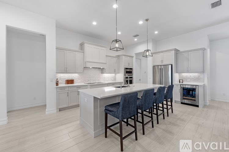 A modern kitchen with a long island and bar stools.