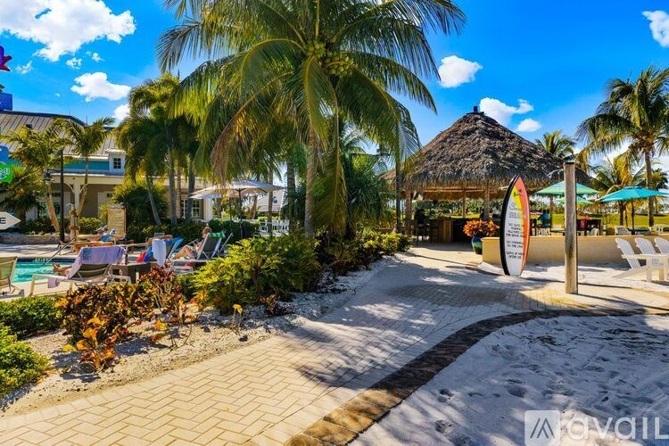A beach scene with a surfboard sign in the foreground.