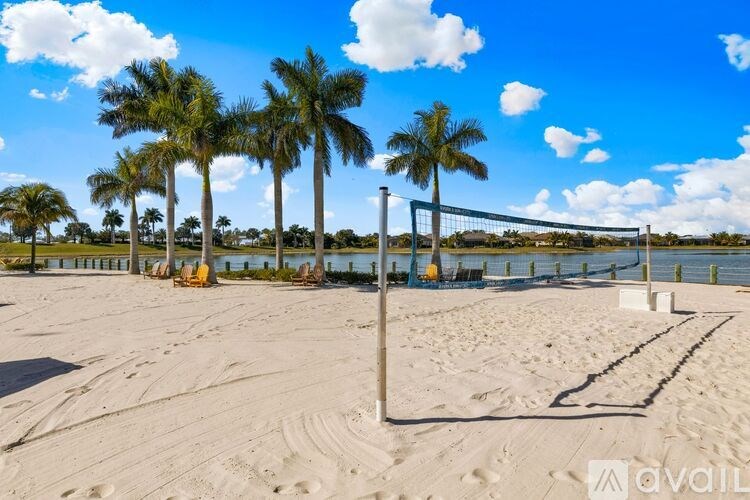 A beach scene with palm trees and a volleyball net.