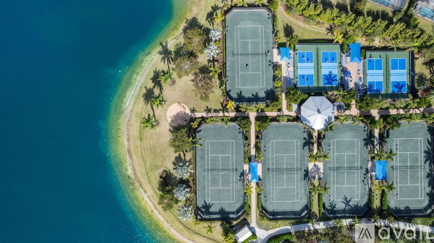 An aerial view of a beachfront with tennis courts and a pavilion.