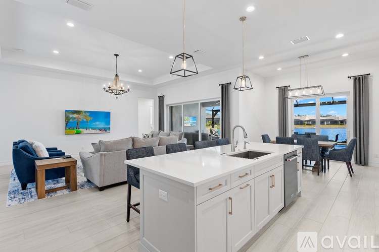 A modern kitchen with a large island and a dining area with a view of the ocean.