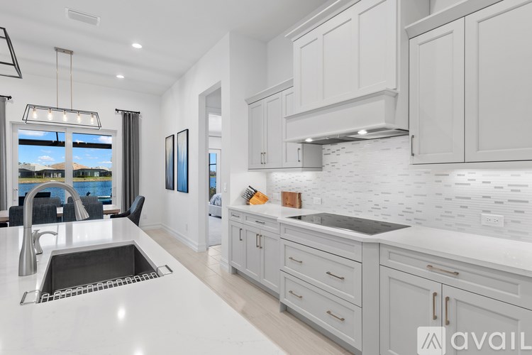 A modern kitchen with white cabinets and a large island.