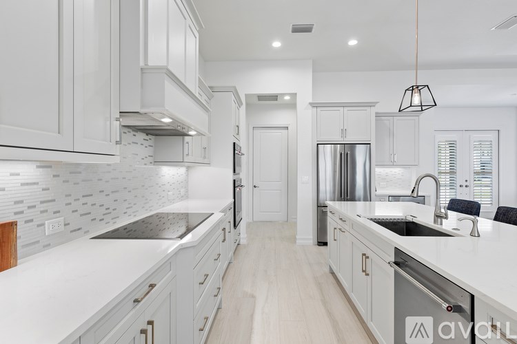 A modern kitchen with white cabinets and a marble countertop.