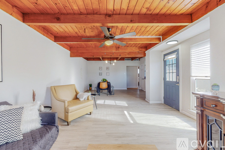 A living room with a yellow chair and a wooden floor.