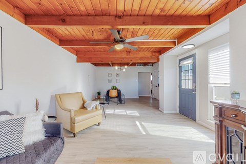 A living room with a yellow chair and a wooden floor.