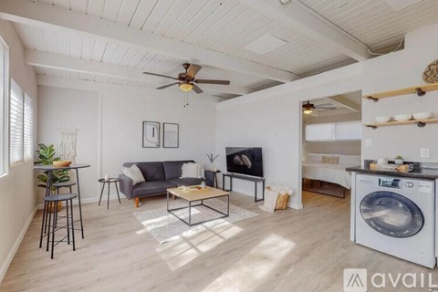 A modern living room with a washing machine in the corner.