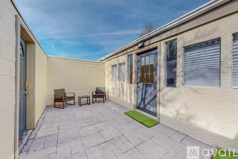 A patio with a table and chairs is in front of a building.