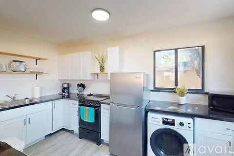 A kitchen with white cabinets and a black dishwasher.