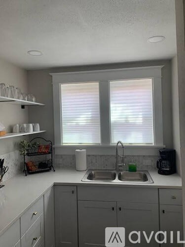 A kitchen with a sink, a window, and a counter.