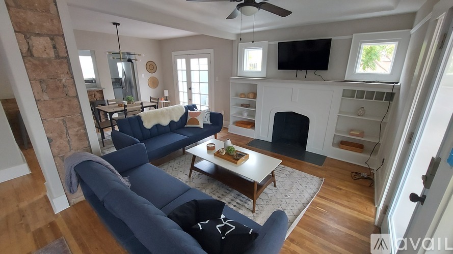 A living room with a blue couch and a fireplace.