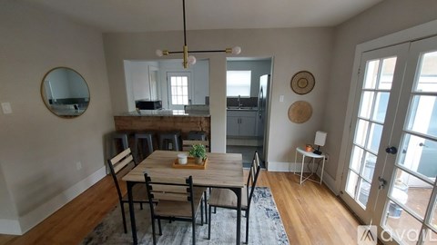 A dining room with a wooden table and chairs.