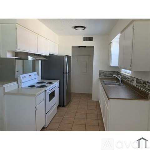 A kitchen with white appliances and cabinets.