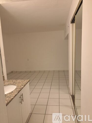 A bathroom with a sink and tiled floor.